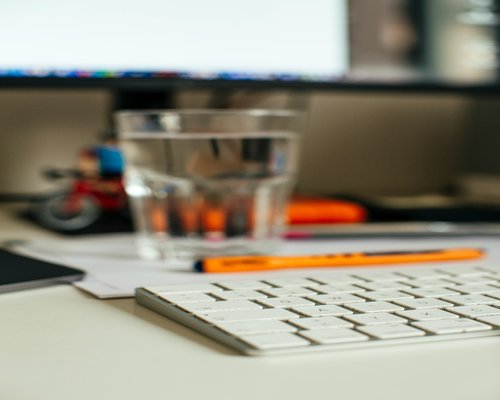 Glass of water and unsweetened cacao drink on an office desk